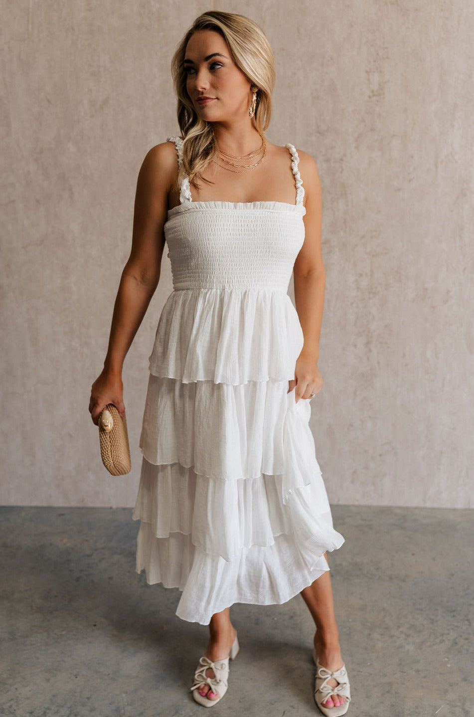 Full body view of female model wearing the Nova Smocked Tiered Midi Dress which features Lightweight Fabric, Fully Lined, Tiered Ruffle Body, Smocked Upper, Square Neckline and Elastic Straps.
