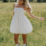 Full body front view of female model wearing the Rosemary White Bubble Hem Mini Dress that has white fabric, a bubble hem, and thin straps.