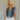 Front view of female model wearing the Brynn Medium Denim Button-Up Vest which features Medium Denim Wash Fabric, Button-Up Front Closure, Cropped Waist, V-Neckline and Sleeveless body.