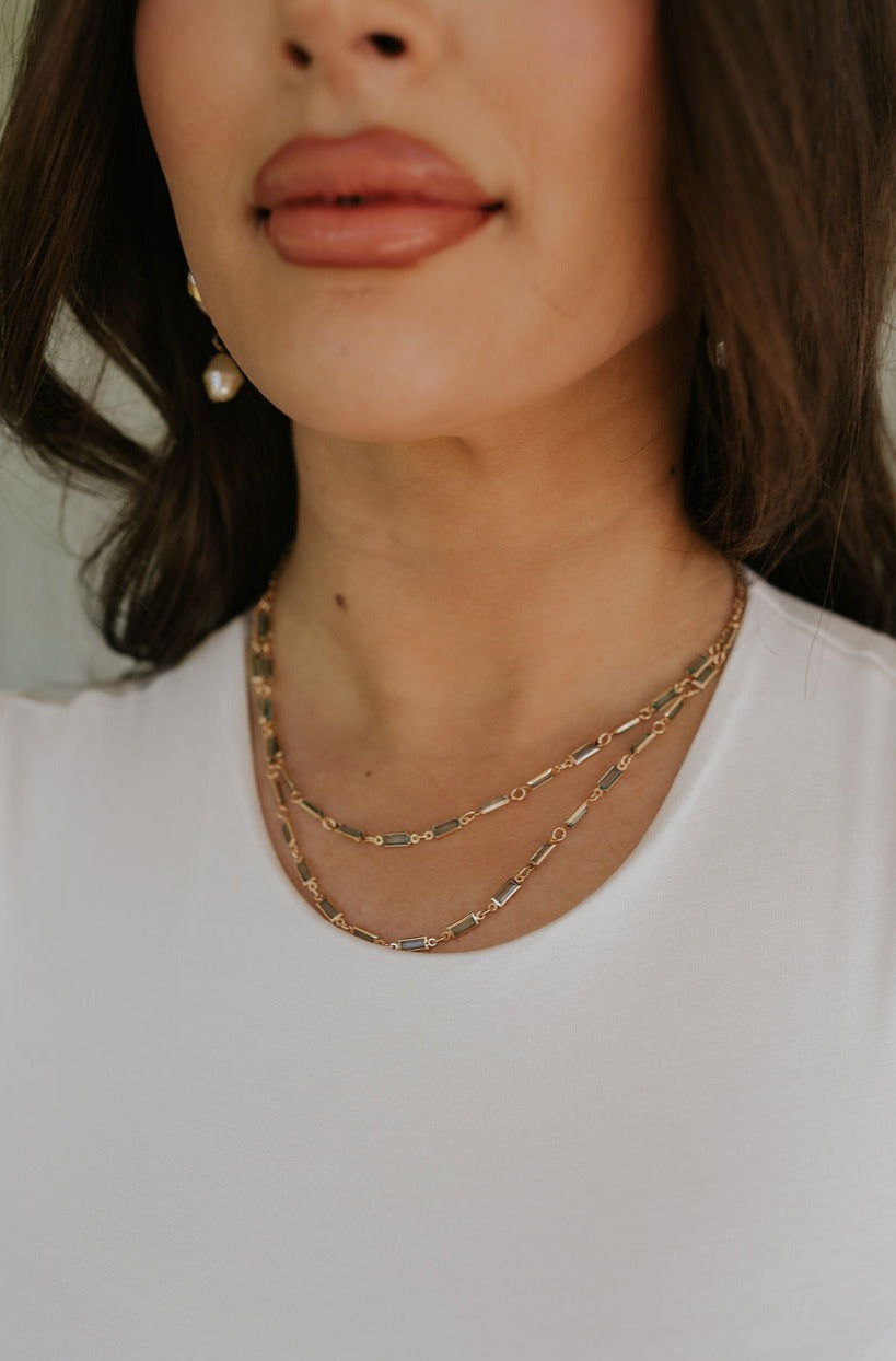 Model is shown in a close-up. She is wearing the Magdelene Necklace in Mint.