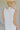 Close up back view of female model wearing the Alayna White Linen Sleeveless Maxi Dress which features White Linen Fabric, Fray Hem Details, Quarter Button-Up, Collared Neckline and Sleeveless