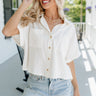 Front view of female model wearing the Cora White Short Sleeve Button-Up Top which features Off White Linen Fabric, Wooden Button Up Front Closure, Collared Neckline, Short Sleeves and Front Chest 