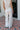 Back view of female model wearing the Alice Off White Wide Leg Drawstring Pants which features Off White Lightweight Linen Fabric, Off White Lining, Wide Pant Legs, Side Pockets and Elastic Waistband with Drawstring Tie