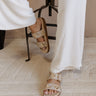 Front view of female model wearing the Revelry Studded Sandal which features light taupe suede upper, gold stud details, double strap, adjustable buckle closure and slide-on style