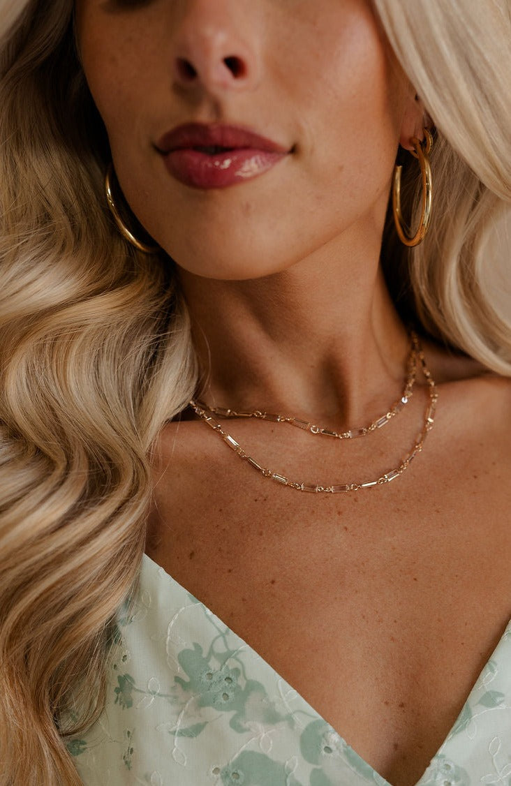 A model is shown in a close-up. She is wearing the Magdelene Necklace in Crystal.