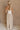  Full body back view of female model wearing the Ellie White & Oatmeal Strapless Maxi Dress which features White Ribbed Upper, Oatmeal Linen Fabric, Maxi Length, Back Slit Detail and Strapless