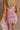 Close up back view of female model wearing the Willow Pink Floral Ruched Mini Dress which features Pink, Light Pink and Green Sheer Fabric, Rose Pattern Detail, Ruched Details, Mini Length, Pink Lining, Drape Detail, Strapless and Monochrome Back Zipper with Hook Closure