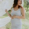 front view of female model wearing the Casey Cream & Blue Striped Midi Dress that has cream and blue horizontal stripes, bodycon fit, thick straps, a side slit, and round neck.