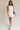 Full body view of female model wearing the Taylor Off White Bow Cut-Out Mini Dress which features White Lightweight Fabric, White Lining, Mini Length, Square Neckline, Side Zipper with Hook Closure and Bow Cut-Out Back Detail
