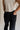 Close up back view of female model wearing the Remi Rhinestone Slit Black Jeans that have black denim, thigh slits with rhinestone trim, and pockets.