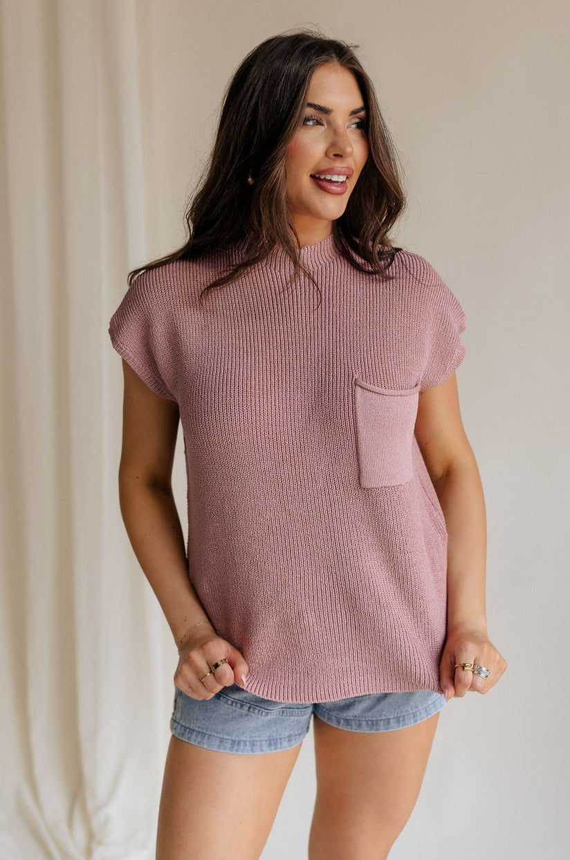 Front view of female model wearing the Arana Knit Short Sleeve Top which features Lightweight Knit Fabric, Slight Slit Details,  Front Left Chest Pocket, Round Neckline and Short Sleeves. the top is available in beige and mauve