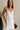 front view of female model wearing the Noelle White Ruffle Plunge Neckline Mini Dress which features White Lightweight Fabric, White Lining, Mini Length, Ruffle Details, V-Neckline and Smocked Back