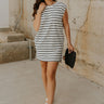 Full body front view of female model wearing the Gabriella Cream & Black Striped Mini Dress that has cream fabric with horizontal black stripes, a sleeveless body, round neck, and side pockets.