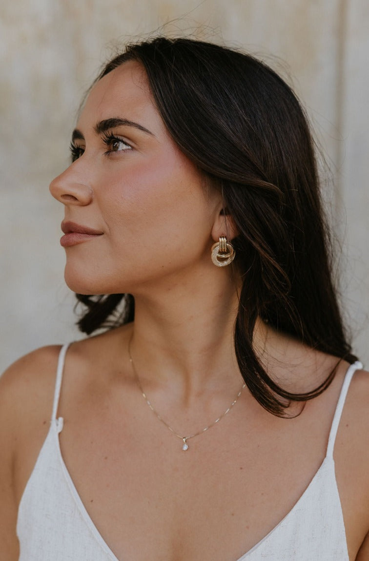 A model is shown from the side wearing the Barbara Earrings. 