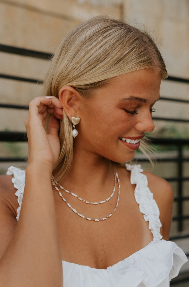 Side view of a model earing the Odessa Pearl Earrings.
