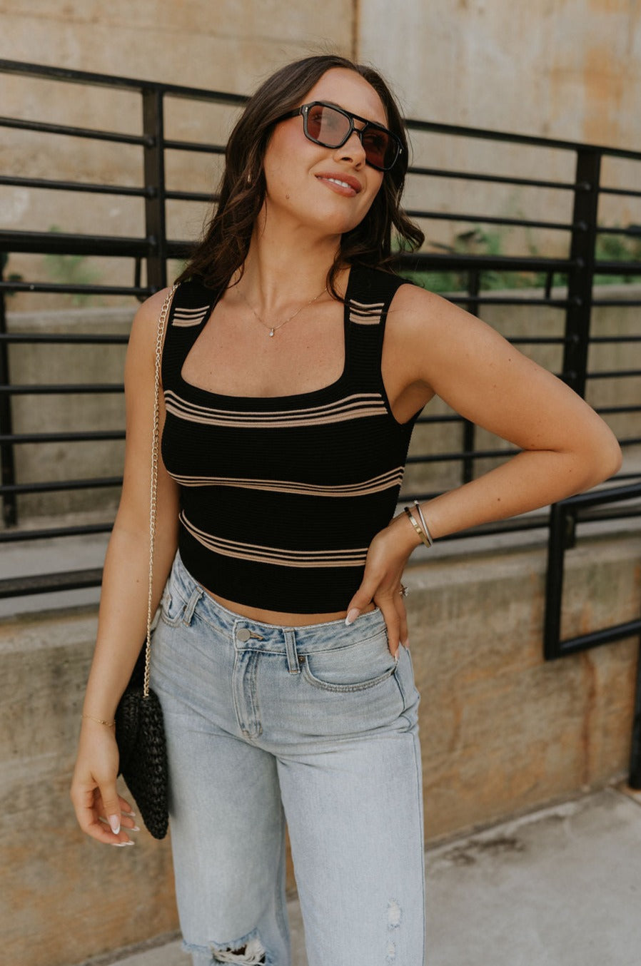 Side view of female model wearing the Shayna Stripe Square Neckline Tank which features Ribbed Fabric, Stripe Pattern, Square Neckline and Sleeveless. the tank is available in black and white