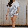 Front view of female model wearing the Bella Rose Stipe Top.  This top is short sleeve with navy and ivory stripes and trimmed in lavender with a crew neck.