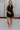 Full body view of female model wearing the Athena Front Zip-Up Halter Romper which features Denim Like Fabric, Pockets on each side, Two Back Pockets, Folded Hem Details, Front Zipper Closure, Collared Neckline and Sleeveless. the romper is available in red and black