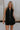 Front view of female model wearing the Athena Front Zip-Up Halter Romper which features Denim Like Fabric, Pockets on each side, Two Back Pockets, Folded Hem Details, Front Zipper Closure, Collared Neckline and Sleeveless. the romper is available in red and black