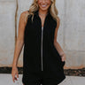 Front view of female model wearing the Athena Front Zip-Up Halter Romper which features Denim Like Fabric, Pockets on each side, Two Back Pockets, Folded Hem Details, Front Zipper Closure, Collared Neckline and Sleeveless. the romper is available in red and black