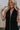 Close up view of female model wearing the Athena Front Zip-Up Halter Romper which features Denim Like Fabric, Pockets on each side, Two Back Pockets, Folded Hem Details, Front Zipper Closure, Collared Neckline and Sleeveless. the romper is available in red and black