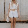 Full body view of female model wearing the Teagan White Square Neckline Romper which features White Linen Fabric, White Lining. Square Neckline, Sleeveless and Monochrome Back Zipper with Hook Closure