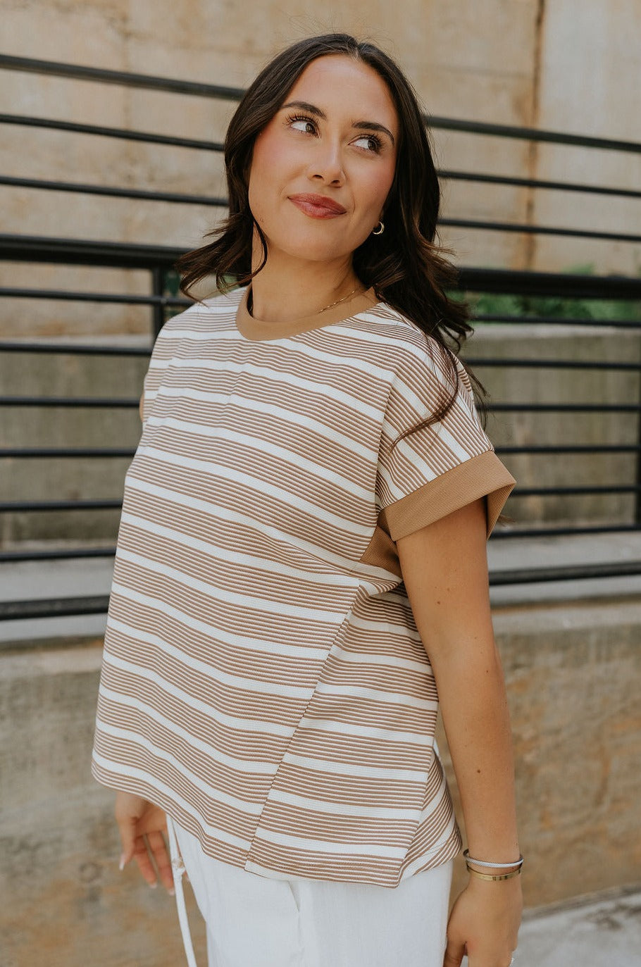 Side view of female model wearing the Celeste Taupe & White Stripe Short Sleeve Top which features Taupe and Cream Lightweight Fabric, Thin Stripe Pattern, Round Neckline and Short Sleeves