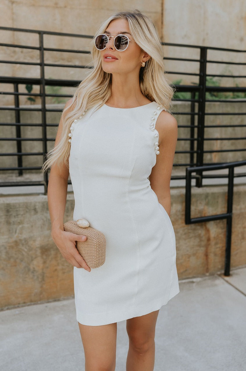 Front view of female model wearing the Eden Cream Pearl Sleeveless Mini Dress which features Cream Textured Fabric, Mini Length, Cream Lining, Round Neckline, Sleeveless, Pearl Details and Back Zipper with Hook Closure