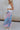 Side view of female model wearing the Lily Aqua & Pink Multi Pleated Maxi Skirt which features Blue, Pink, Red, Purple and Aqua Floral Print, Satin Pleated Fabric, Maxi Length, Light Blue Lining and Side Zipper with Hook Closure