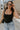Front view of female model wearing the Andrea Black Square Neckline Sleeveless Bodysuit which features Black Lightweight Fabric, Square Neckline, Sleeveless and Thong Bottom with Button Snap Closure