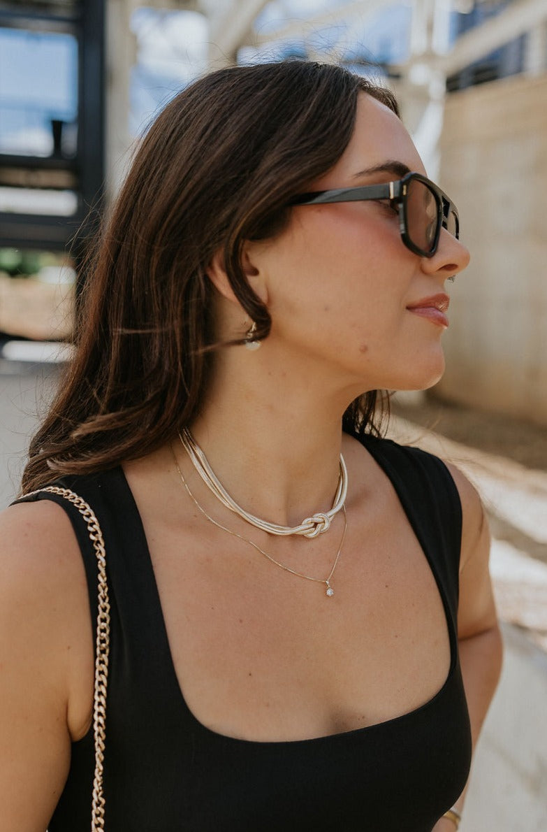 The model is shown from the side. She is wearing the Jessica Knot necklace. 