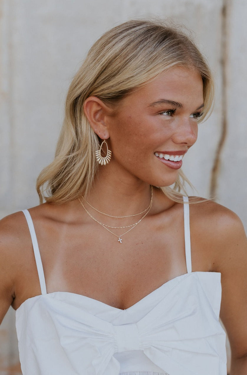 A model is shown wearing the Helena Stack Necklace. 