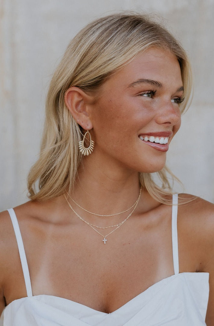 A model is shown wearing the Helena Stack Necklace.