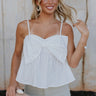 Front view of female model wearing the Alina Off White Bow Poplin Tank which features White Lightweight Fabric, Cropped Waist, Front Oversized Bow Detail, Adjustable Straps and Monochrome Back Zipper with Hook Closure