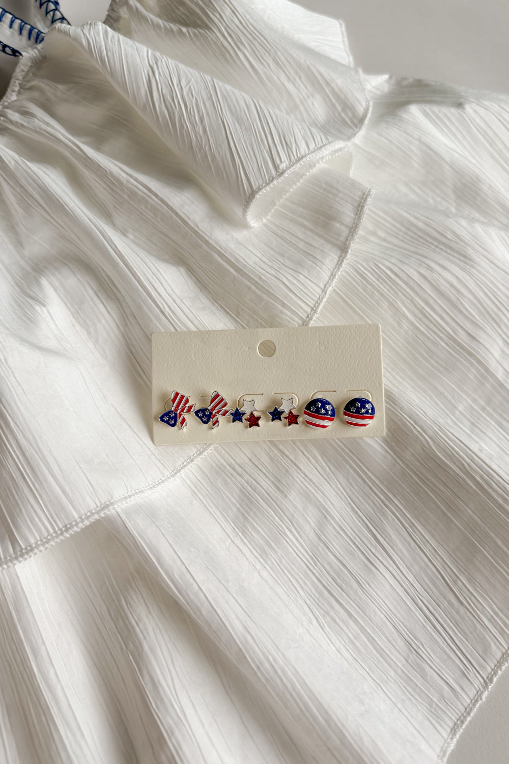Image shows Kennedy Stars & Stripes Stud Set that have 3 pairs or studs; bows, circles, and stars. Studs are red white and blue with stripe details.