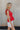 Side view of Kelly Red Ruffle Tank that has linen tie details and ruffle details throughout, zipper on back.