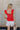 Back view of Kelly Red Ruffle Tank that has linen tie details and ruffle details throughout, zipper on back.