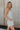 Side view of Alyssa Floral Romper that is light blue and cream, with a V neckline, spaghetti straps, and mini length.