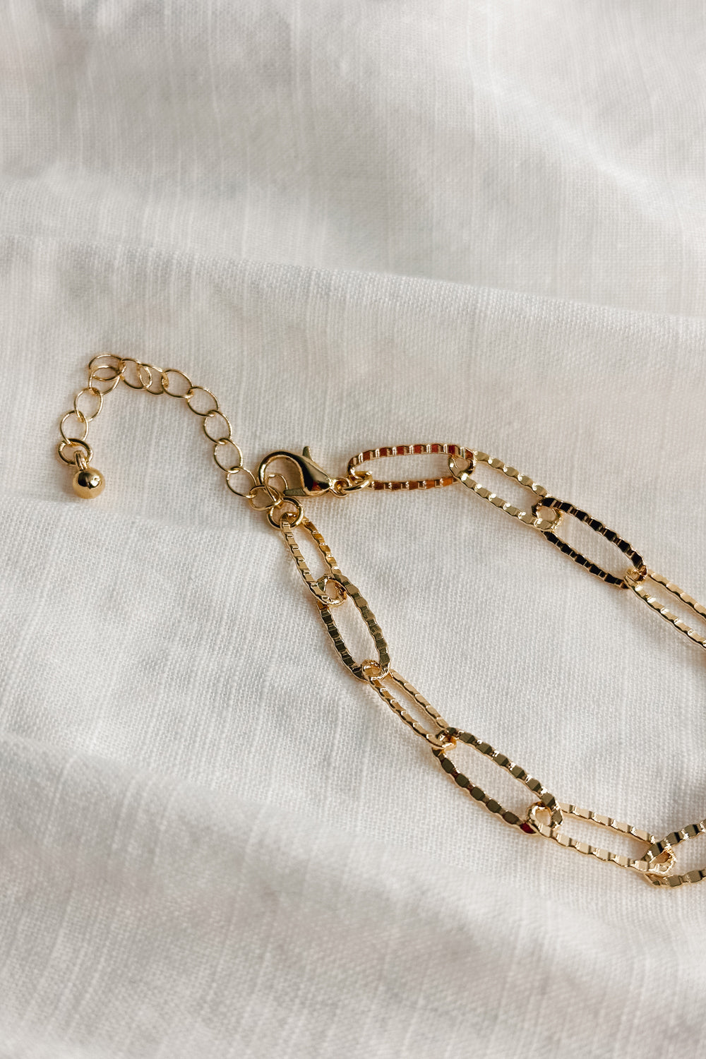 Image shows the Bethany Gold Textured Chain Link Bracelet against a white background. Bracelet has gold textured oval links.
