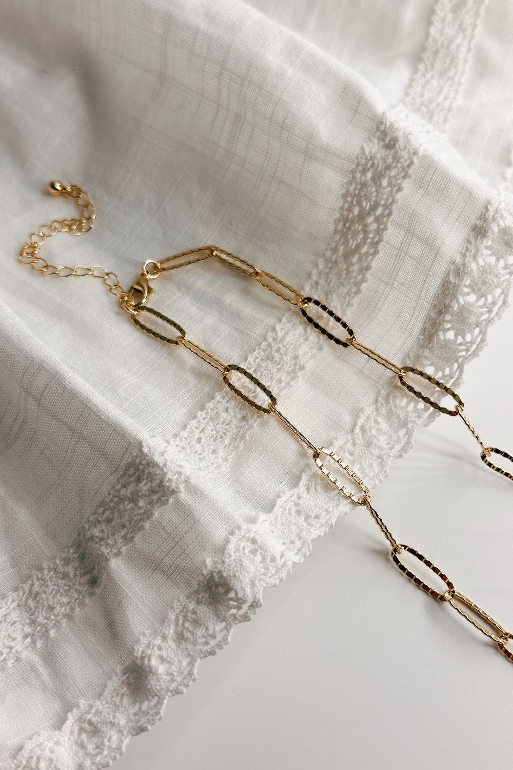 Image shows the closure of the Sadie Gold Textured Chain Link Necklace against a white background. Necklace has skinny oval gold textured chain links. Shown without charms.