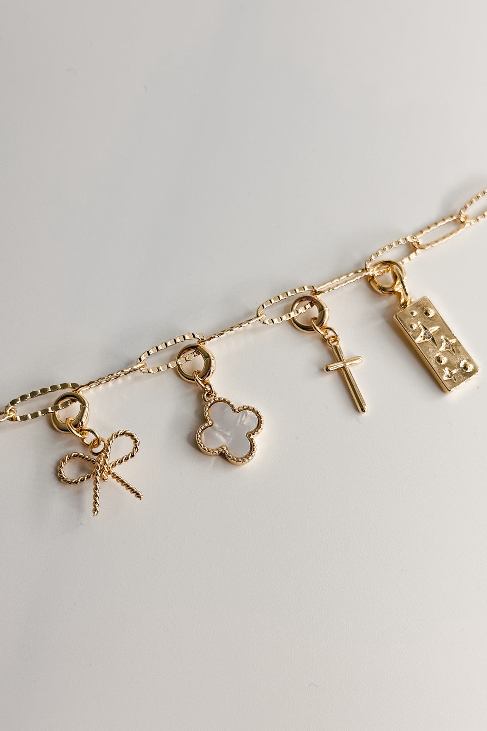 Image shows the Bethany Gold Textured Chain Link Bracelet against a white background. Shown with 4 charms attached to bracelet.