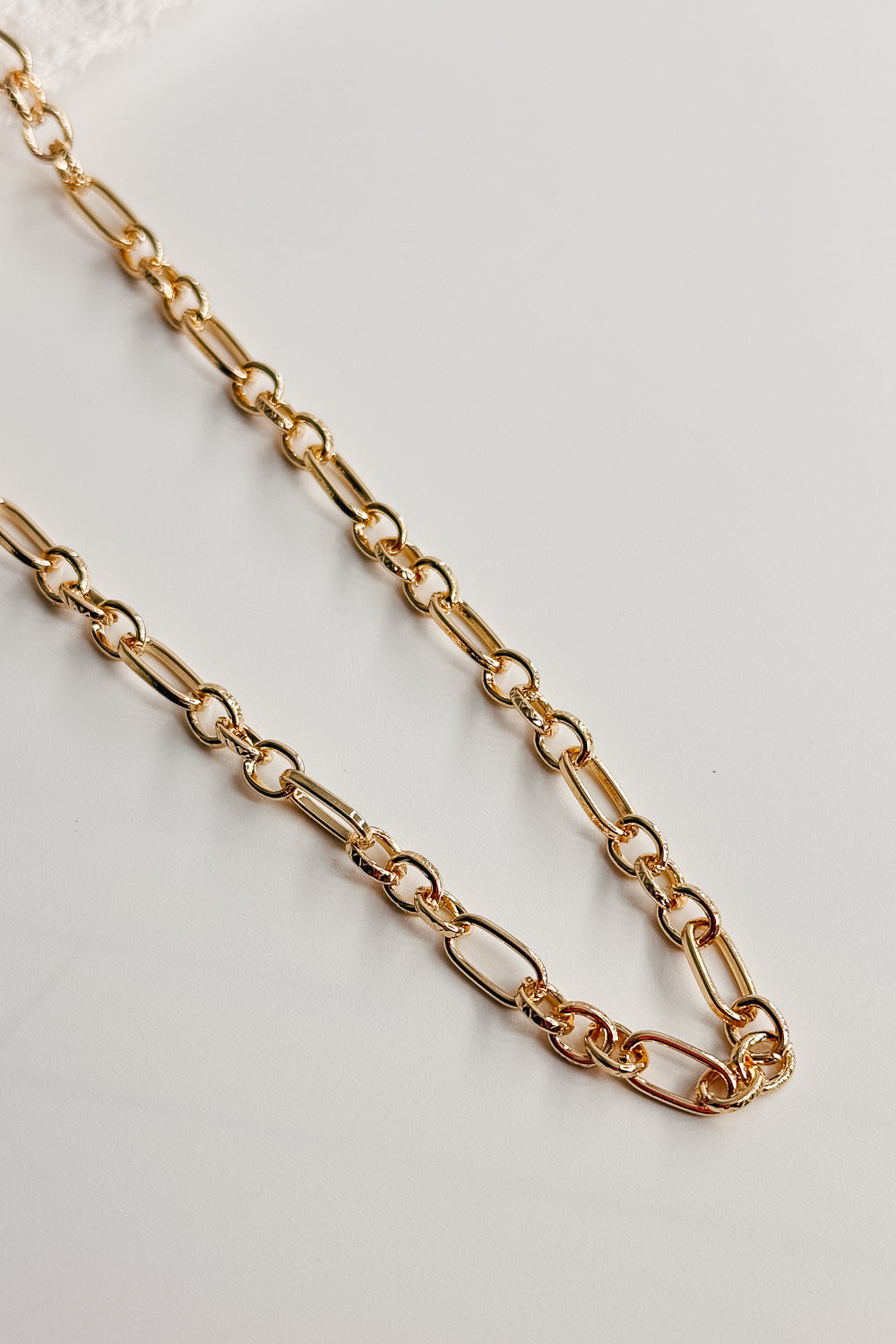 Image shows the bottom of the Kennedy Gold Chain Link Necklace against a white background. Necklace has gold circle and oval links. Shown without charms.