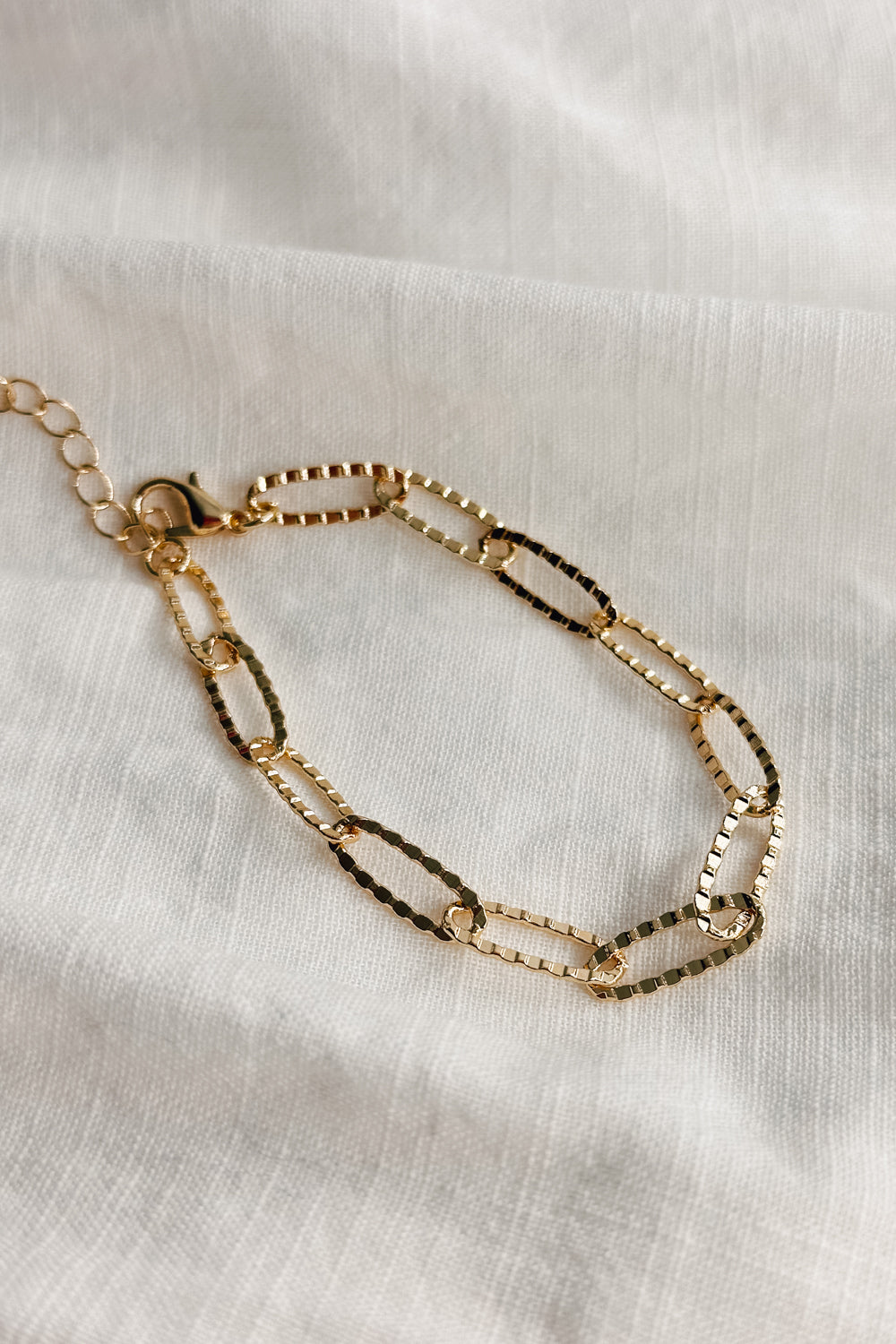 Image shows the Bethany Gold Textured Chain Link Bracelet against a white background. Bracelet has gold textured oval links.