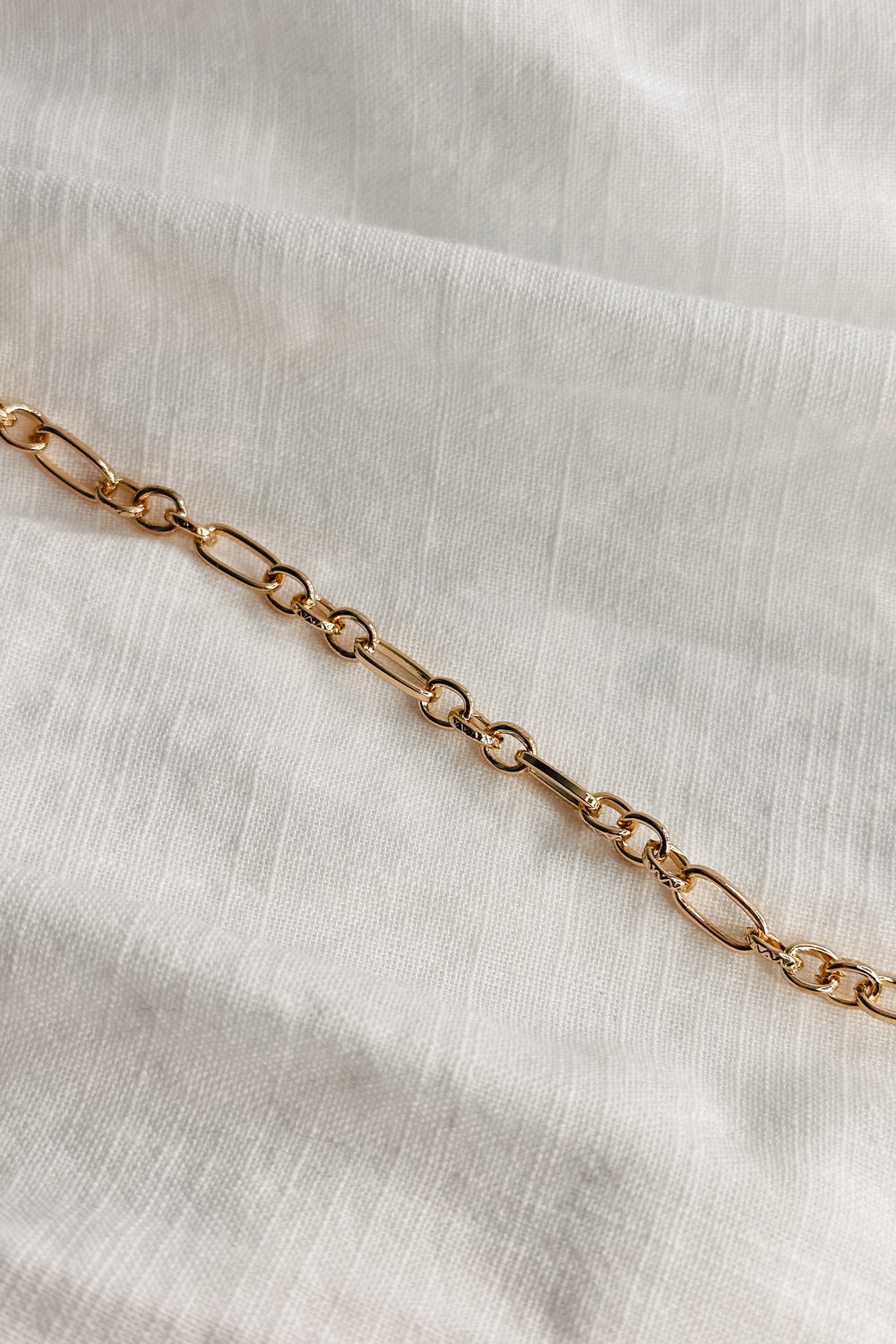 Image shows the Reagan Gold Chain Link Bracelet against a white background. Bracelet has gold circle and oval links. 
