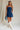 full body view of female model wearing the Amaya Strapless Flare Mini Dress which features  Lightweight Fabric, Side Zipper Closure, Belt Loops, Two Front Pockets, Strapless and Shorts Lining. the dress is available in red and navy blue