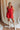 Full body view of model wearing Gabby Red Romper. This is a washed red romper with fray details.