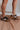 Image shows side view of model's legs- model is wearing the Dolce Vita Notice Stitch Sneaker in Dark Leopard.