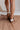 Image shows back view of model's legs- model is wearing the Dolce Vita Notice Stitch Sneaker in Dark Leopard.