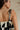 close up back view of female model wearing the Lila Black & Cream Tie Straps Romper which features Black and White Geometric Pattern, White Shorts Lining, Two Side Pockets, Ruffle Upper, Square Neckline and Tie Straps