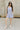 Full body view of model wearing the Ariana Grey Romper. This is a grey romper, sleeveless, with pockets.